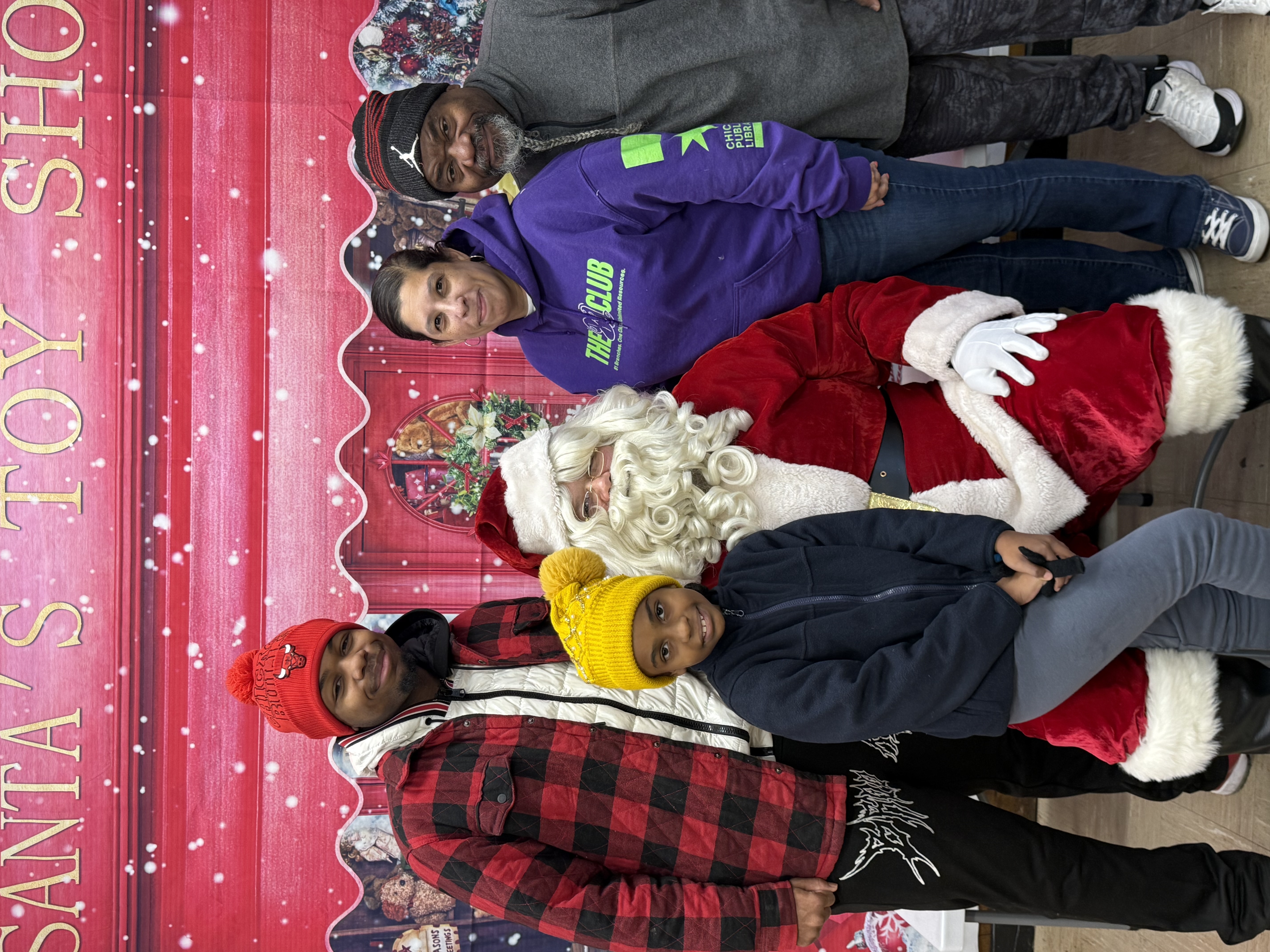 Photograph of a group with Santa at a Santa's Toy Shop event.